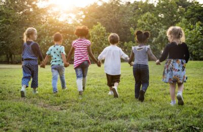 Children holding hands running in the field