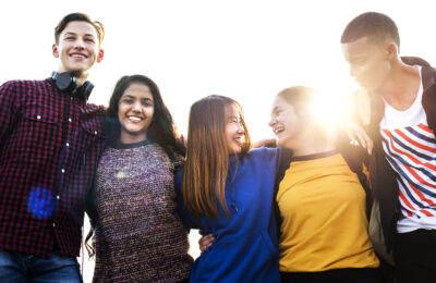 Group of school friends outdoors arms around one another togetherness and community concept