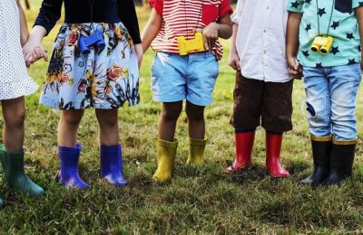 Children holding hands, wearing wellington boots