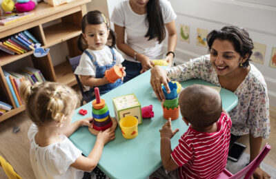 Nursery children playing and teacher
