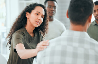 Woman comforting a peer member in a support group.