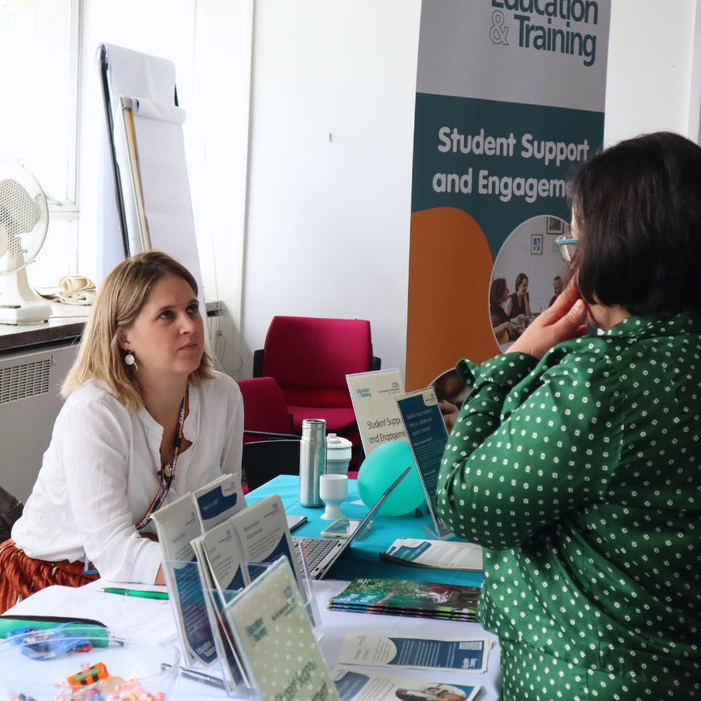 A student support advisor takling to a prospective student. 
