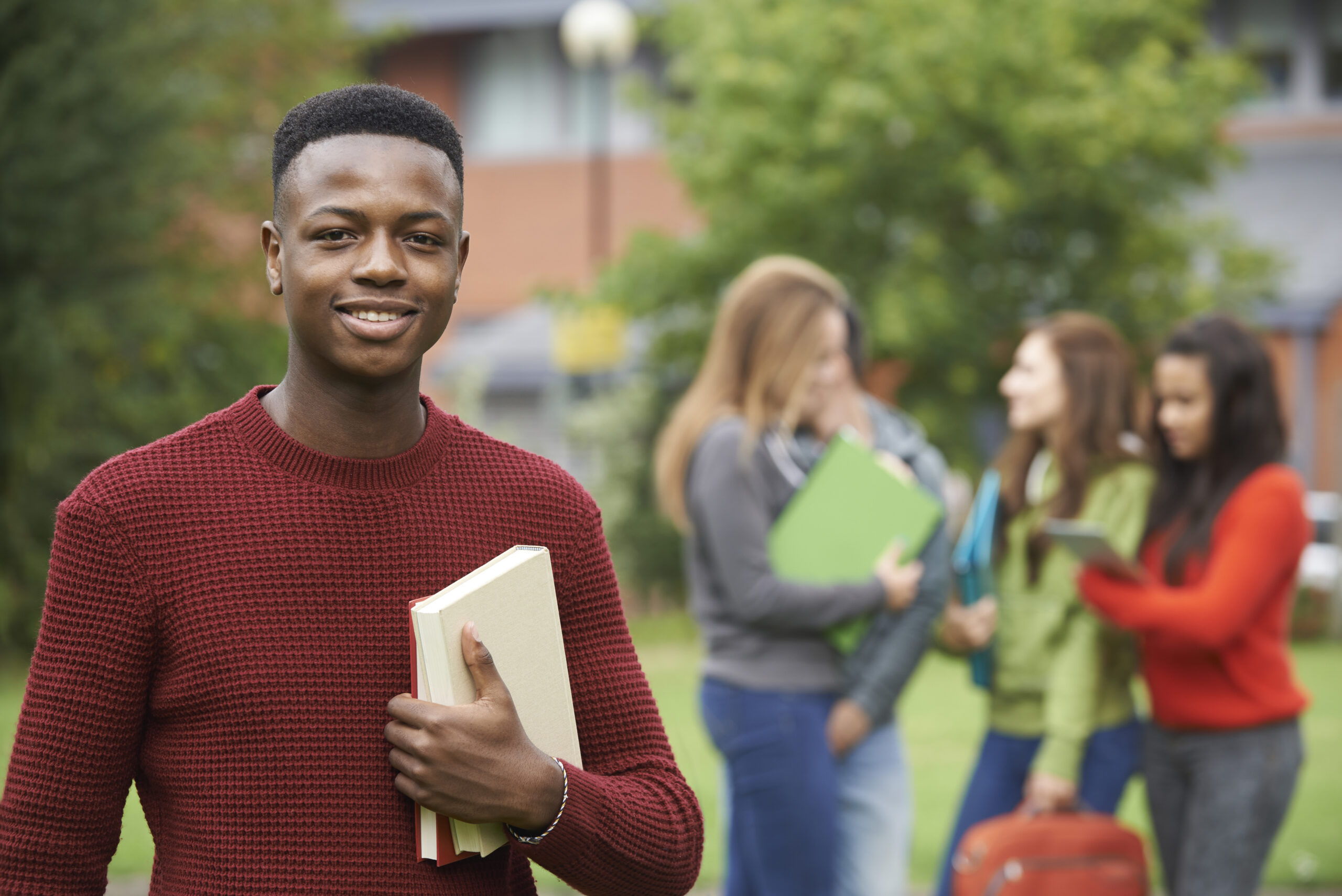 A smiling teenager standing in front of a group of other teenagers