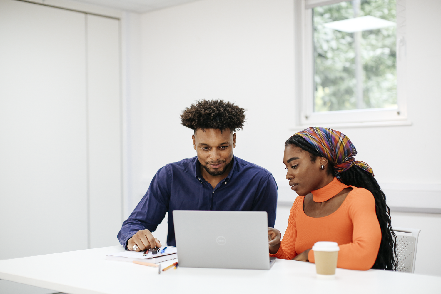 Two students working at a laptop