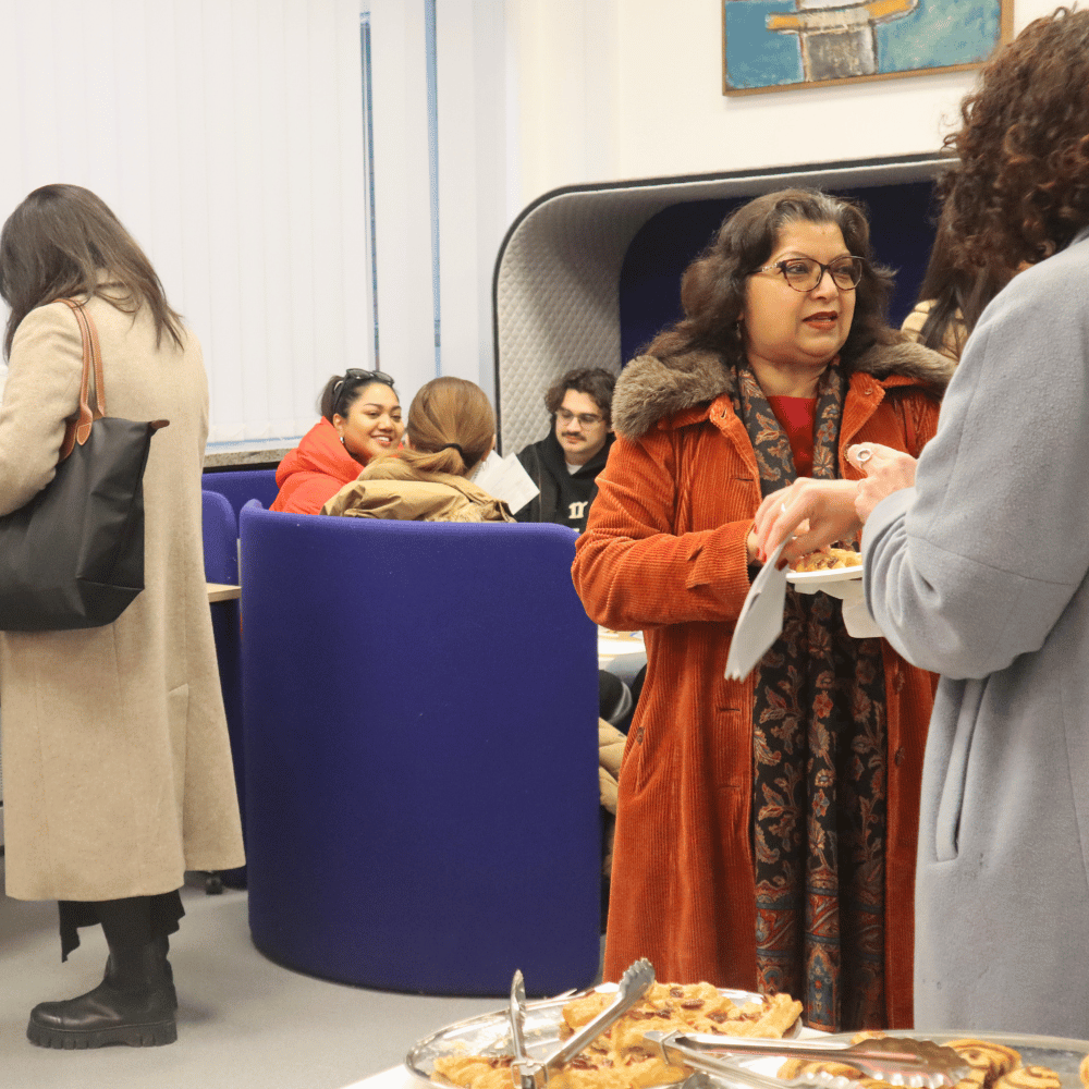 Visitors chatting in foyer with food and drinks 