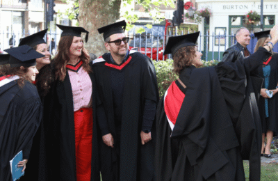 Graduates pose for a selfie outside graduation ceremony.